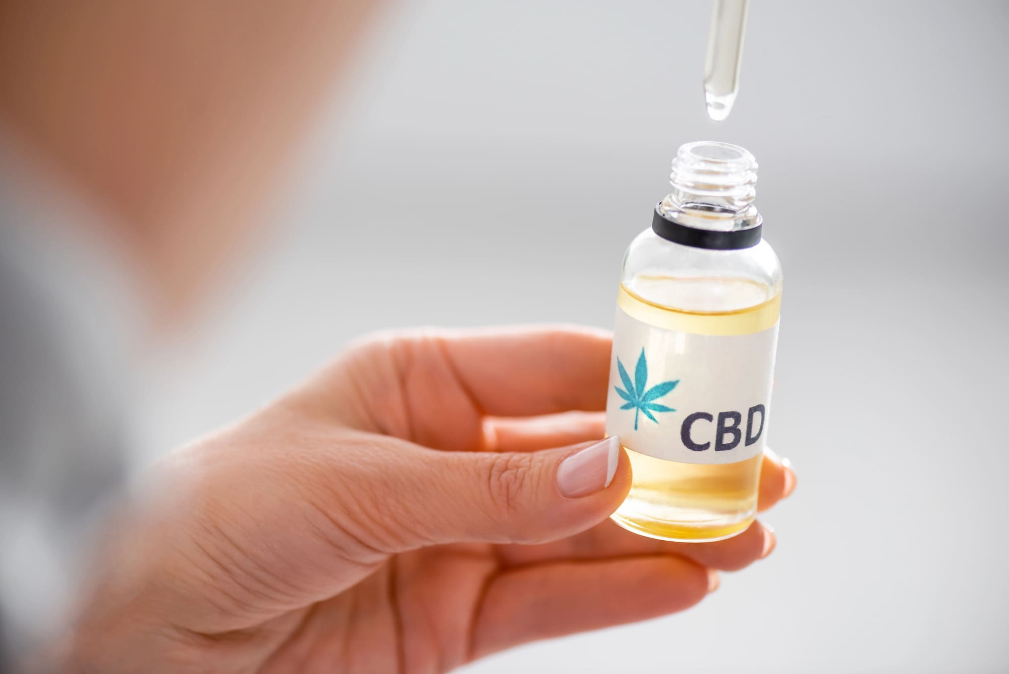 Olej CBD - działanie i zastosowanie. Kobieta trzyma olejek CBD w ręku